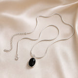 Colar Oval Preto em Tom de Ouro Branco