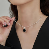 Colar Oval Preto em Tom de Ouro Branco